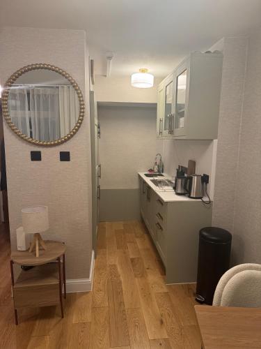 a kitchen with a counter and a sink and a mirror at Central London Apartment in London