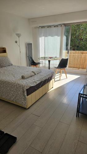 une chambre avec un lit, une table et des chaises dans l'établissement Julie's House Paris 20, à Paris