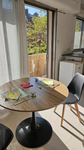 Cette chambre comprend une table en bois et une cuisine. dans l'établissement Julie's House Paris 20, à Paris