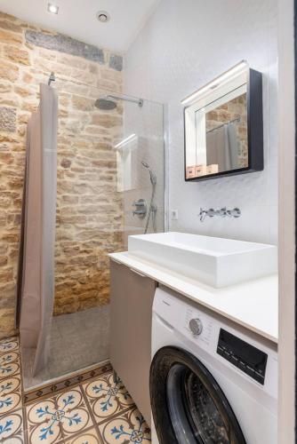 une salle de bain blanche avec un lavabo et une douche dans l'établissement Appartement cosy plein centre - l'Annexe, à Lyon