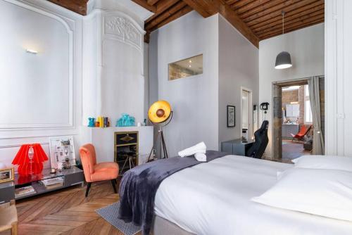 une chambre avec un grand lit blanc et une chaise dans l'établissement Appartement cosy plein centre - l'Annexe, à Lyon