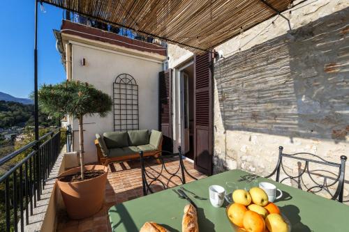 une table avec un bol de fruits sur un balcon dans l'établissement Apt Matisse - Au cœur du village de Saint-Paul de Vence, à Saint-Paul-de-Vence