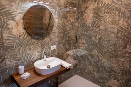 a bathroom with a sink and a mirror on a wall at LM HOME Crosia in Mirto
