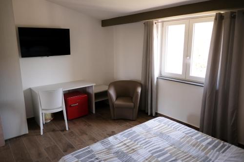a bedroom with a bed and a desk and a window at LM HOME Crosia in Mirto
