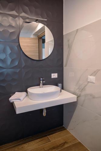 a bathroom with a sink and a mirror at LM HOME Crosia in Mirto