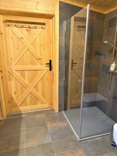 a bathroom with a shower and a sliding barn door at Chata Przesieka in Przesieka
