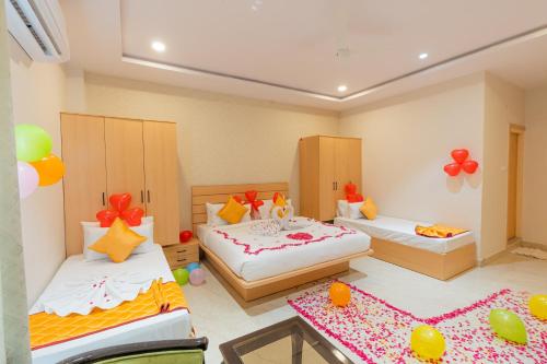 two beds in a room with balloons on the floor at Serene Resort Hyderabad in Shamshabad