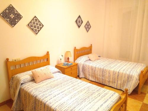 a bedroom with two beds and a table with a lamp at Piso Calle Pelayo in Villanueva de Córdoba