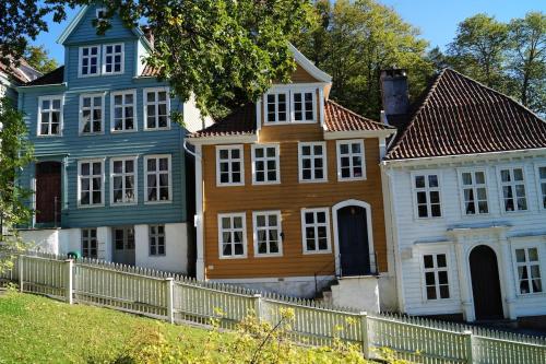 a group of houses next to a white fence at Nice apartment in modern complex near Old Bergen in Bergen