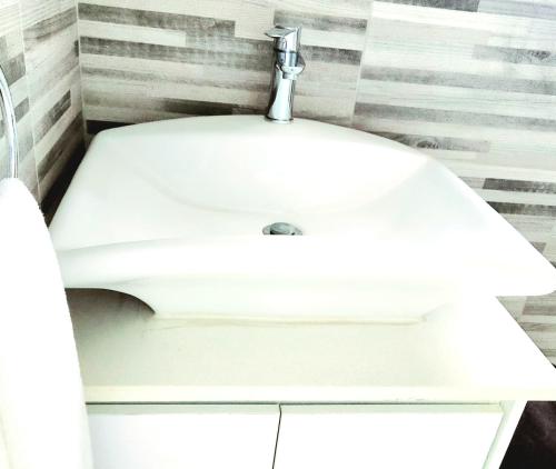 a bathroom with a white sink in a bathroom at Tlokweng Rose Garden Guesthouse in Gaborone