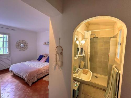 une chambre avec un lit et une salle de bain avec un lavabo dans l'établissement Authentique mas provençal avec charme, Villecroze, à Villecroze
