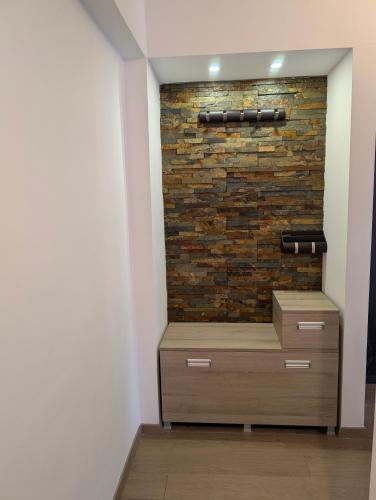 a room with a brick wall and a dresser at Apartament central 3 dormitoare in Tîrgu Secuiesc