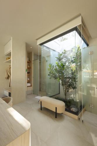 a room with a window and a bench and a plant at Eden Resort & Villas Phuket Patong in Patong Beach