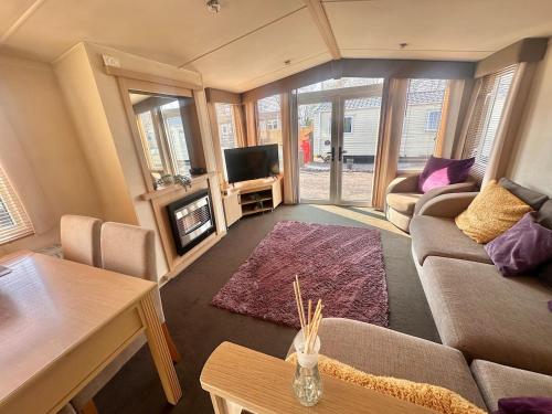 a living room with a couch and a tv at Swift Moselle 2 Bedroom Caravan Located in Uddingston, Glasgow at Maryville Caravan Site in Uddingston