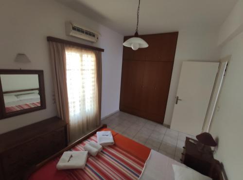 a room with a bed and a mirror and a door at Sunflower House in Vathi, Ithaka