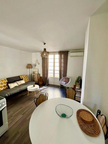 un salon avec une table blanche et un canapé dans l'établissement Ajaccio centre ville joli T2 Grandval, à Ajaccio