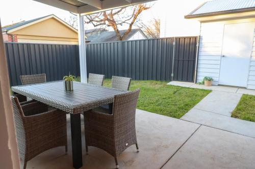 a table with chairs and an umbrella on a patio at Ellamatta House Simmons St Central Wagga in Wagga Wagga
