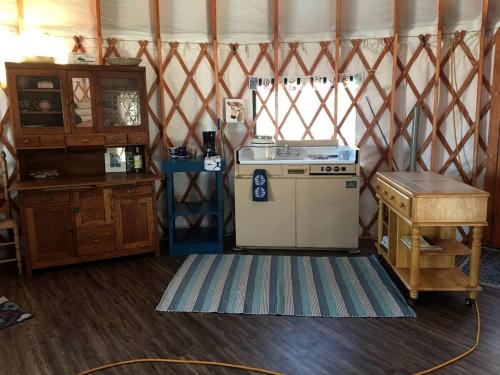 eine Küche mit einem alten Herd und einem Tisch in der Unterkunft Gorgeous Gibbon Yurt Ideal for Glamping in Nebraska in Kearney