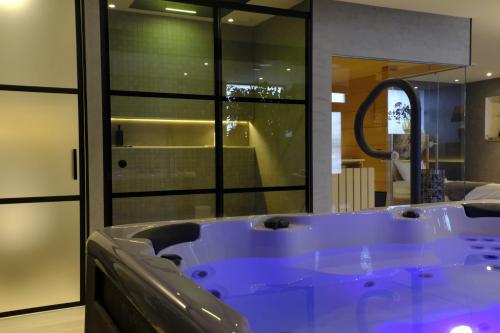 a large blue tub in a room with a mirror at Bed & Wellness De Leilinde in Nieuwe-Niedorp