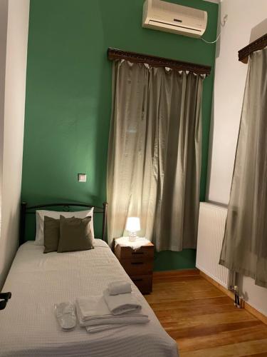 a bedroom with a bed with a green wall at Varvayanni Villa in Plomarion