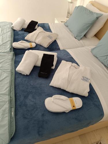 a bed with towels and flip flops on it at Artist Home in Porto Rafti