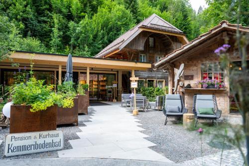 una casa con patio y sillas frente a ella en Hotel Kemmeriboden-Bad AG, en Schangnau