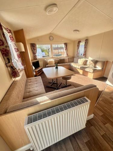 a living room with a couch and a table at Two Bedroom Willerby Caravan Located in Uddingston, Glasgow at Maryville Caravan Site in Uddingston