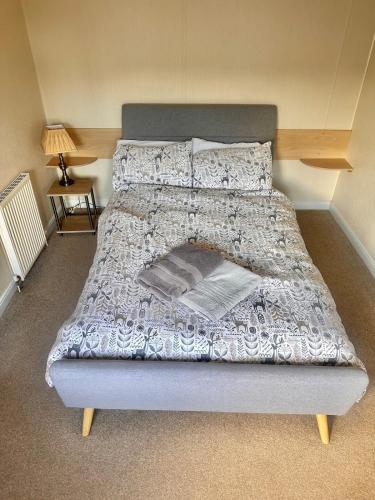 a bedroom with a large bed with a white comforter at Two Bedroom Willerby Caravan Located in Uddingston, Glasgow at Maryville Caravan Site in Uddingston