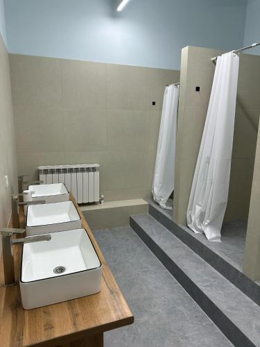 a bathroom with three toilets and a sink at Hostel O2 in Almaty