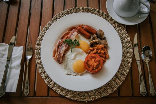 a plate of breakfast food with eggs sausage and beans at Rhino's Rest Private Luxury Villa in Hoedspruit