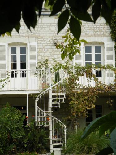 a white spiral staircase in front of a house at Hôtel Diderot in Chinon