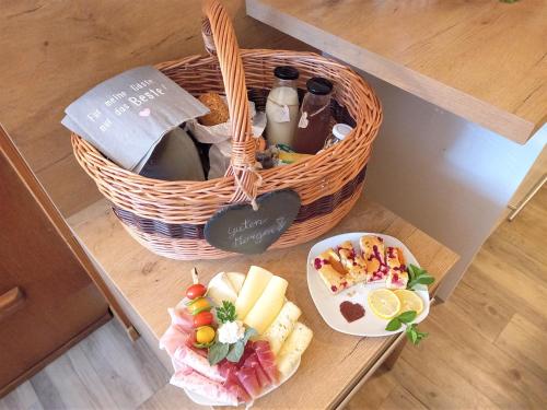 a table with a basket of food and a plate of fruit at Haus Karin living in Brixen