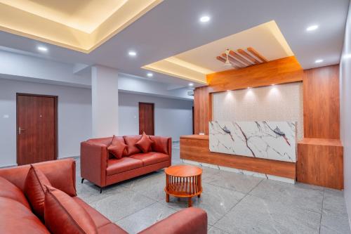 a waiting room with two leather chairs and a screen at Daan Residency Near Karukapilly Kaloor Palarivattom in Ernakulam