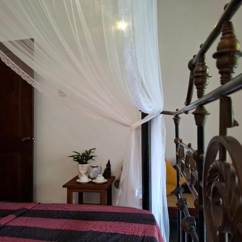 a bedroom with a bed with a canopy at Room by the MANGO TREE in Nugegoda