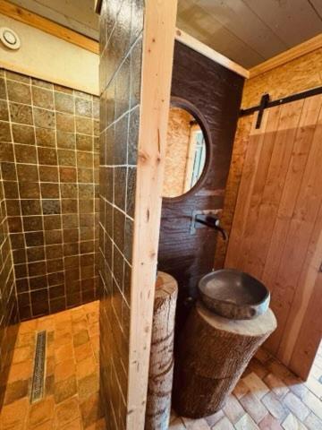 - une petite salle de bains avec des toilettes et une porte dans l'établissement Le bout du monde, à Saint-Quentin-en-Tourmont