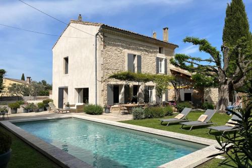 une maison avec une piscine devant une maison dans l'établissement Mas de village au calme, à Entraigues-sur-la-Sorgue