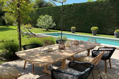 une table et des chaises avec une table et une piscine dans l'établissement Mas de village au calme, à Entraigues-sur-la-Sorgue