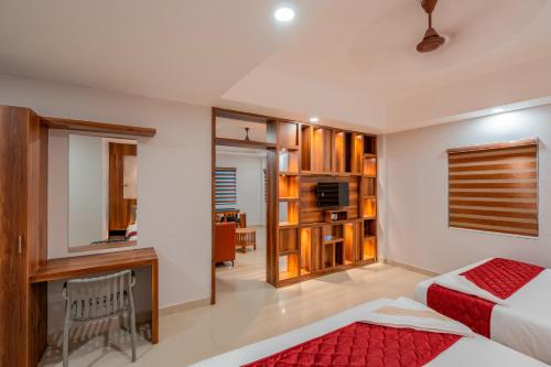 a bedroom with a bed and a desk and a television at Daan Residency Near Karukapilly Kaloor Palarivattom in Ernakulam