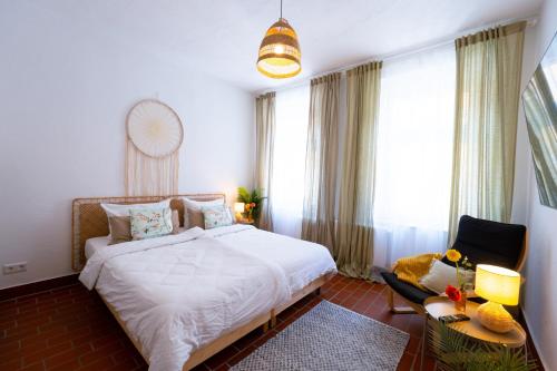 a bedroom with a large white bed and a chair at BetterBeds BRB - Apartment - Zentral - Smart TV - Küche - WLAN in Brandenburg an der Havel