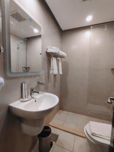 a bathroom with a sink and a mirror and a toilet at منتجع شاطئ الدولفين للإيواء السياحي in Yanbu