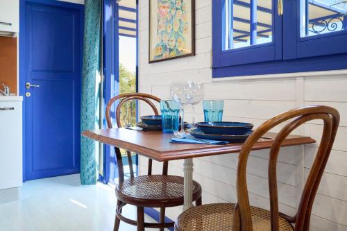 a dining room with blue cabinets and a wooden table with chairs at Poggio Diavolino - Suvereto in Suvereto