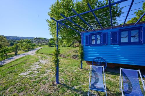 a blue house with two chairs in front of it at Poggio Diavolino - Suvereto in Suvereto