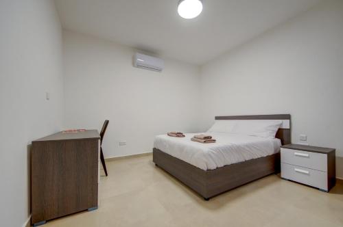 a bedroom with a bed with a nightstand and a bed sidx sidx sidx sidx at The Valley Collection - Suite A2 in Xagħra