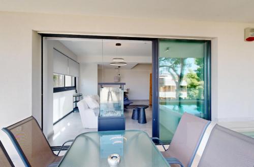 a glass table and chairs in a room with a view at Κ2 Varkiza Seaside Residences in Vari
