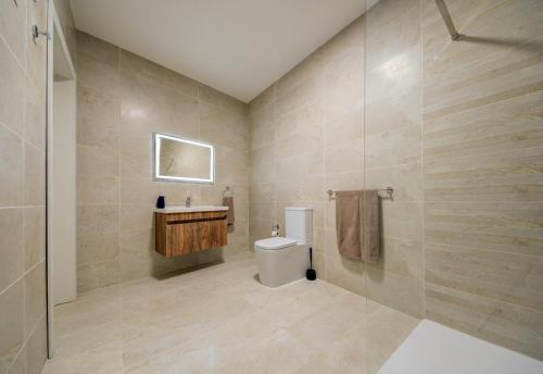 a bathroom with a toilet and a sink at The Valley Collection - Suite A2 in Xagħra