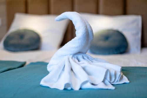 a towel animal sitting on top of a bed at OŚRODEK KOLONIJNO WCZASOWY MEWA - przy plaży z basenem z podgrzewaną wodą i mini SPA in Niechorze