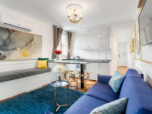 un salon avec un canapé bleu et une cuisine dans l'établissement Merveil - Luxury Suite - Champs Elysees - Royale I, à Paris