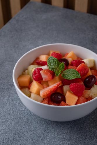 a bowl of fruit with berries and mint on a table at Element Al Jaddaf, Dubai in Dubai