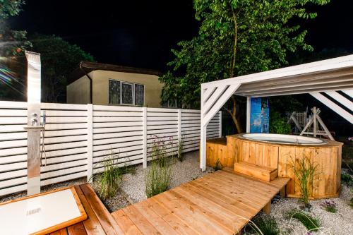 a wooden deck with a hot tub in a fence at OŚRODEK KOLONIJNO WCZASOWY MEWA - przy plaży z basenem z podgrzewaną wodą i mini SPA in Niechorze