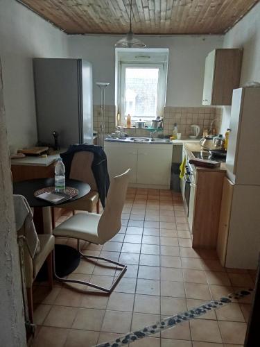 une cuisine avec une table et des chaises dans une pièce dans l'établissement Privat Zimmer in einer Wohnung zu vermieten, à Mulhouse